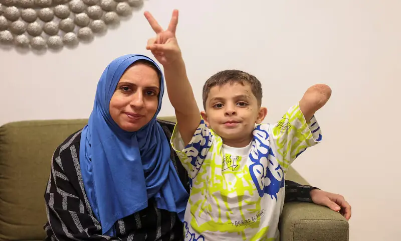 Omar Abu Kuwaik, six-year-old Gazan child who lost an arm in Israeli bombing, gestures and poses next to his aunt and caretaker, Maha Abu Kuwaik in Beirut, Lebanon. – Reuters Omar Abu Kuwaik, six-year-old Gazan child who lost an arm in Israeli bombing, gestures and poses next to his aunt and caretaker, Maha Abu Kuwaik in Beirut, Lebanon. – Reuters