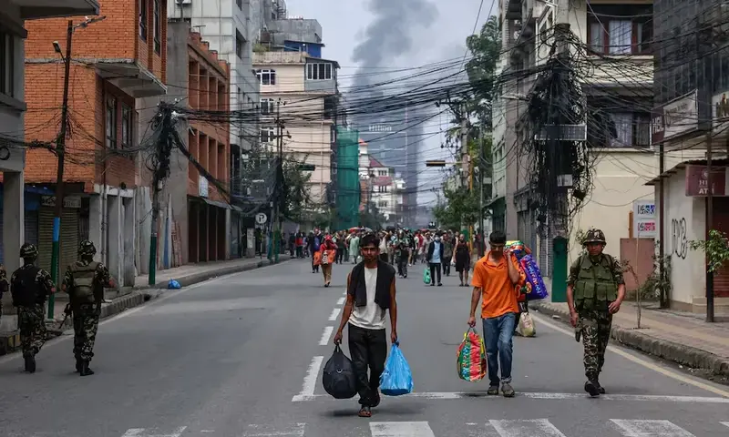 Smoke rises from the burnt Hilton Kathmandu hotel in the distance as prisoners carrying belongings walk back to Dilli Bazaar jail, next to a soldier, after escaping and being sent back by the Nepalese army, following protests against Monday’s killing of 19 people after anti-corruption protests triggered by a social media ban which was later lifted, in Kathmandu, Nepal, September 10. REUTERS Smoke rises from the burnt Hilton Kathmandu hotel in the distance as prisoners carrying belongings walk back to Dilli Bazaar jail, next to a soldier, after escaping and being sent back by the Nepalese army, following protests against Monday’s killing of 19 people after anti-corruption protests triggered by a social media ban which was later lifted, in Kathmandu, Nepal, September 10. REUTERS