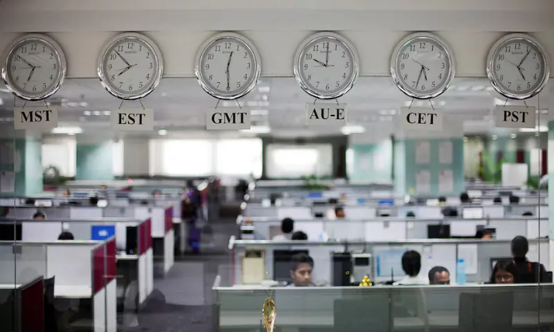 Workers are pictured beneath clocks displaying time zones in various parts of the world at an outsourcing centre in Bangalore. – Reuters file Workers are pictured beneath clocks displaying time zones in various parts of the world at an outsourcing centre in Bangalore. – Reuters file