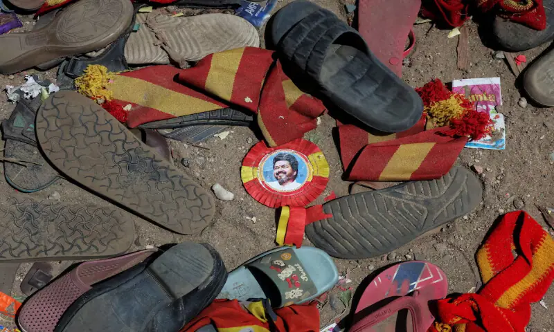 A badge with picture of actor Vijay lies amid footwears and other belongings left by attendees at the site of a stampede in Karur district of Tamil Nadu, India, on Sunday. – Reuters A badge with picture of actor Vijay lies amid footwears and other belongings left by attendees at the site of a stampede in Karur district of Tamil Nadu, India, on Sunday. – Reuters