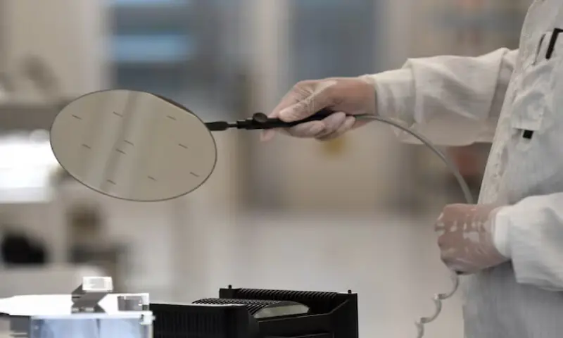 An employee works with a wafer in a production line of semiconductor company Nexperia in Hamburg, Germany. – Reuters file