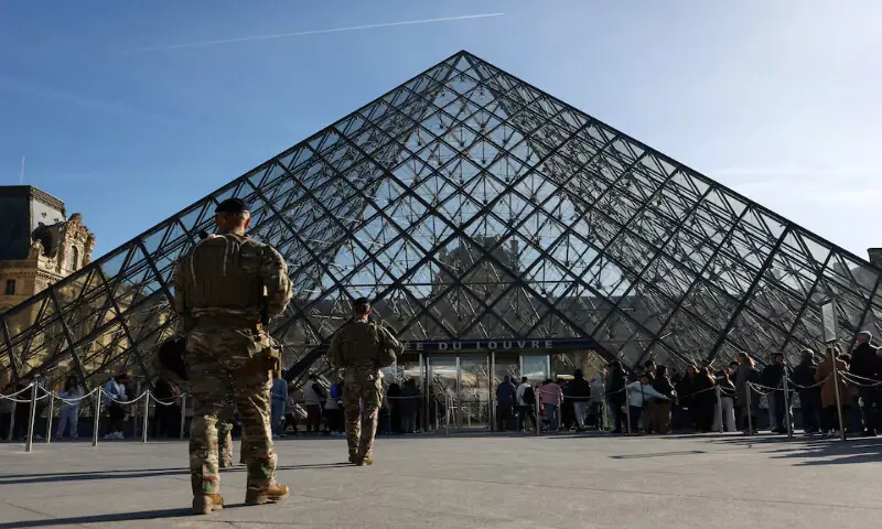French soldiers patrol past the glass Pyramid while people queue to enter the Louvre Museum in Paris, France. – Reuters
