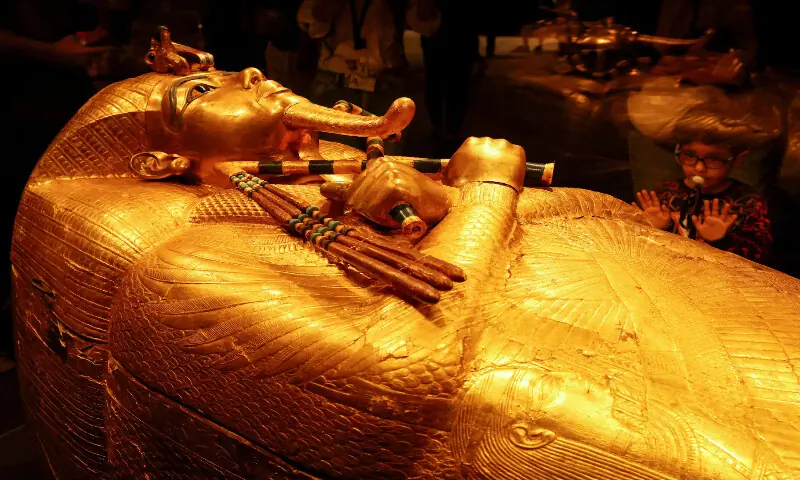 A child looks at the golden coffin of ancient Egyptian Pharaoh Tutankhamun during the first day for visitors after the official opening of the Grand Egyptian Museum, near the Giza pyramid complex, in Giza, Egypt. – Reuters