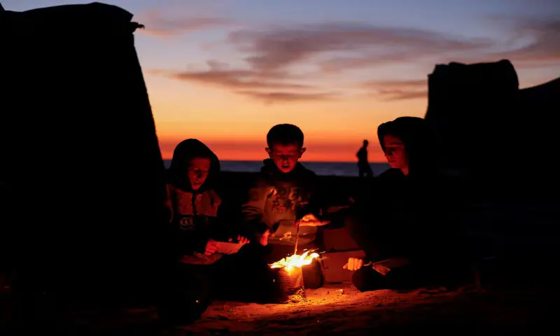 Palestinian children sit next to a fire amid a ceasefire between Israel and Hamas in the central Gaza Strip. – Reuterts Palestinian children sit next to a fire amid a ceasefire between Israel and Hamas in the central Gaza Strip. – Reuterts