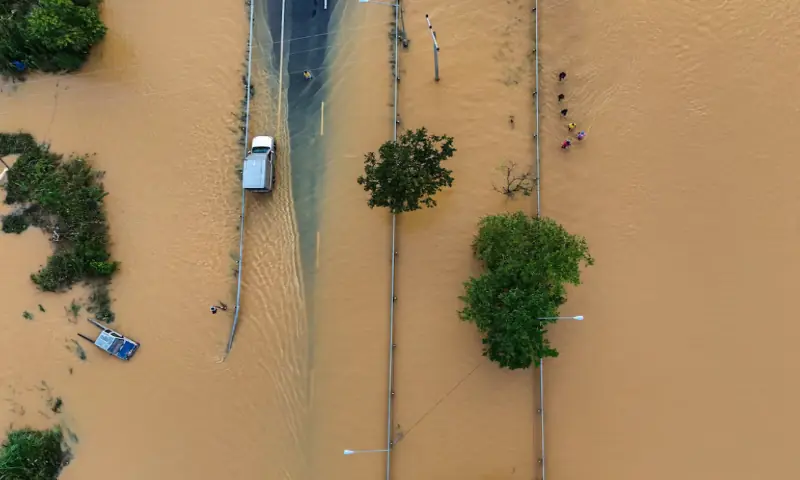 A drone view shows people wading through a flooded area in the Hat Yai district, affected by deadly flooding following heavy rainfall in southern Thailand. – Reuters