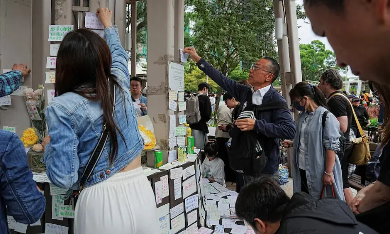People paste sticky notes with well-wishes for those affected by the deadly fire at the Wang Fuk Court housing complex, in Tai Po, Hong Kong, China, November 30, 2025. REUTERS