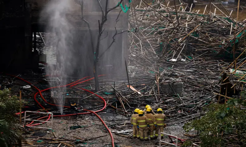 Firefighters gather next to bamboo scaffolding debris at the Wang Fuk Court housing complex after the deadly fire, in Tai Po, Hong Kong, China, December 1, 2025. – Reuters