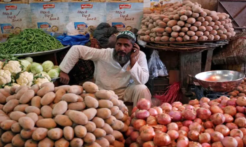 A man selling vegetables waits for customers at his makeshift stall at the Empress Market in Karachi on April 2, 2018. Reuters file