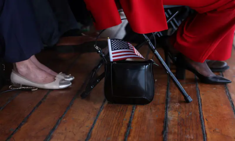 A U.S. flag sticks out from the purse of a citizen candidate attending a U.S. Citizenship and Immigration Services (USCIS) naturalisation ceremony aboard the 1885 Tall Ship Wavertree at the South Street Seaport in New York City, U.S., June 14, 2023. — Reuters