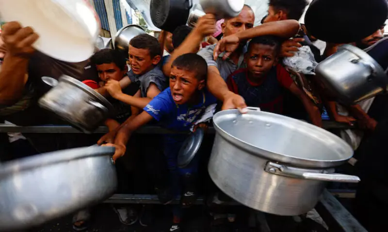 Palestinians gather to receive food from a charity kitchen in Nuseirat, central Gaza Strip. – Reuters file Palestinians gather to receive food from a charity kitchen in Nuseirat, central Gaza Strip. – Reuters file