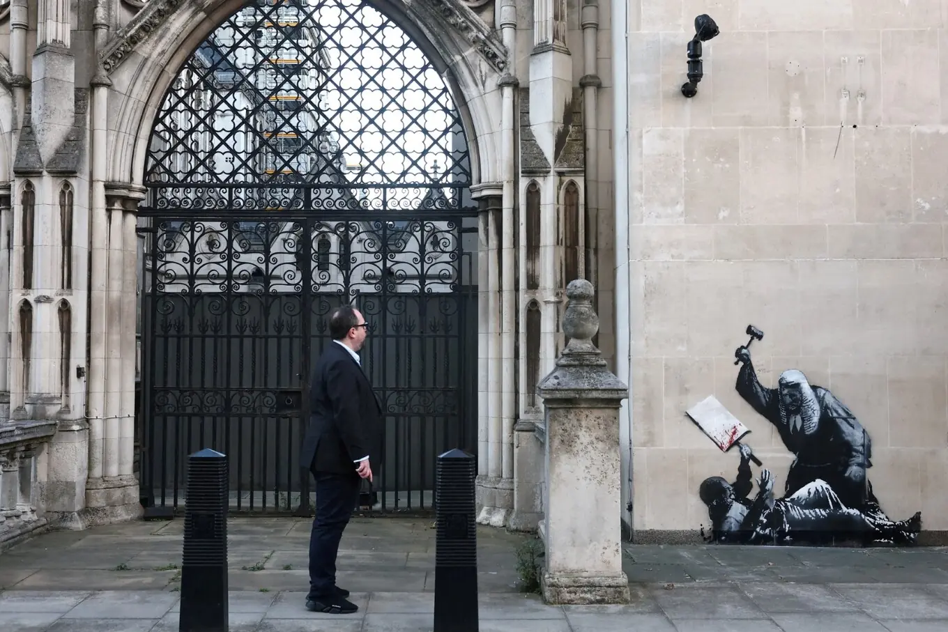 9 ستمبر 2025 کو لندن، برطانیہ میں ایک شخص رائل کورٹ آف جسٹس پر بینکسی کے نئے مرال کو دیکھتے ہوئے