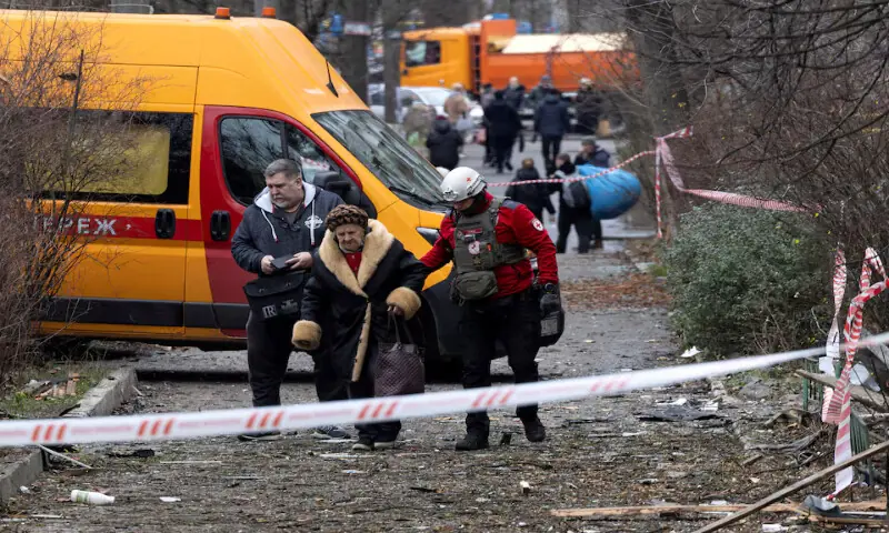 A medic assists a resident as she leaves her apartment building that was hit by a Russian drone in Kyiv, Ukraine. &ndash; Reuters