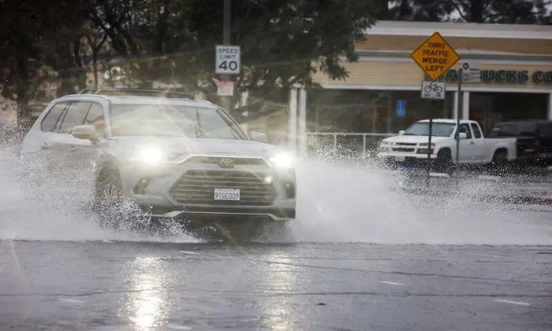 Cars drive through puddles at an intersection in the Woodland Hills area of Los Angeles. &ndash; Reuters