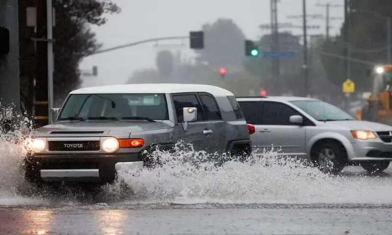 Cars drive through puddles as heavy rain falls in an intersection in the Woodland Hills area of Los Angeles. &ndash; Reuters