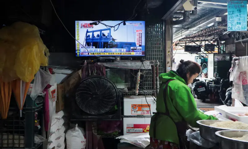 A woman works in a noodle store near a television screen showing a news report on China&rsquo;s &ldquo;Justice Mission 2025&rdquo; military drills around Taiwan, in Taipei, Taiwan. &ndash; Reuters