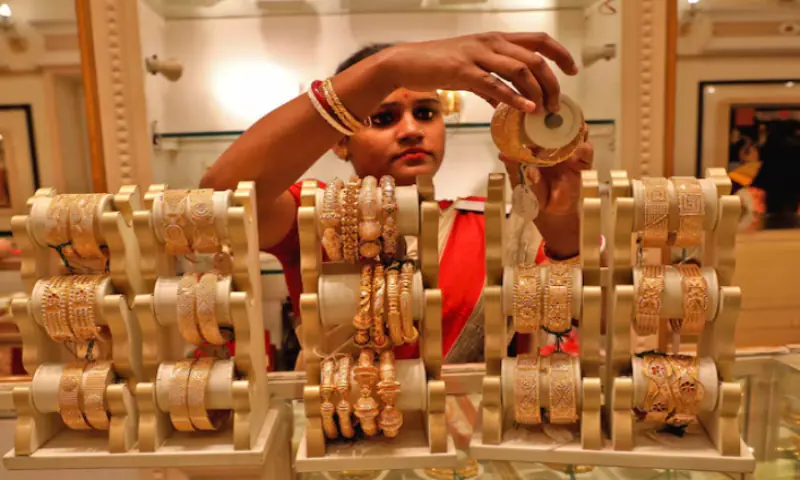A saleswoman shows gold bangles to a customer at a jewellery showroom in Kolkata, India. &ndash; Reuters