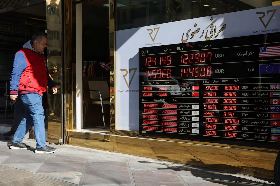 A person walks past a sign at a currency exchange, as the value of the Iranian Rial drops, in Tehran, Iran. – Reuters A person walks past a sign at a currency exchange, as the value of the Iranian Rial drops, in Tehran, Iran. – Reuters