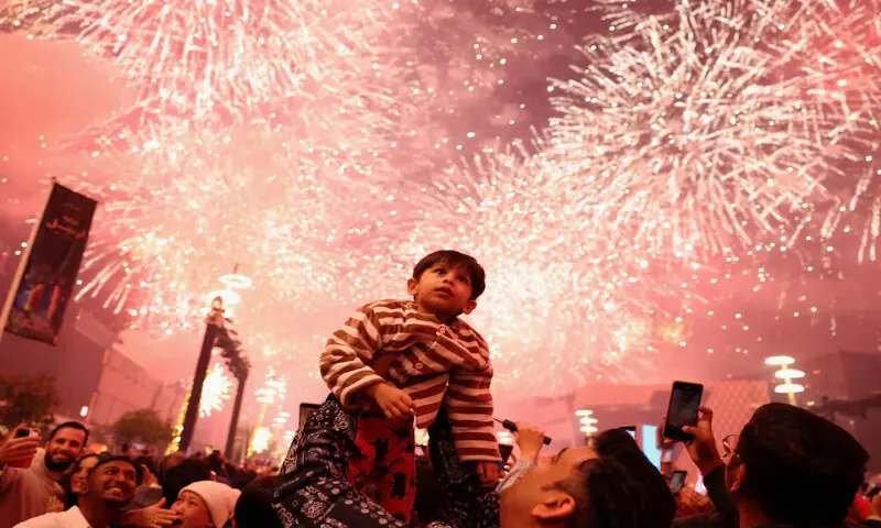 A child looks up as fireworks explode during New Year&rsquo;s celebrations in Lusail, Qatar. &ndash; Reuters