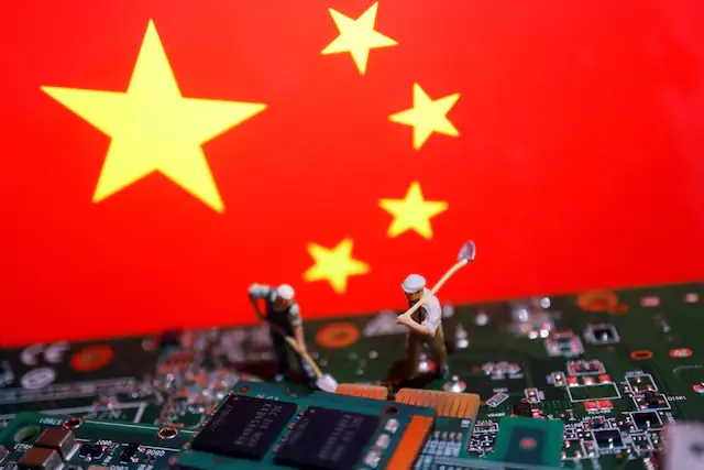 Worker miniatures are placed among the flags of China and printed circuit boards with semiconductor chips. &ndash; Reuters file