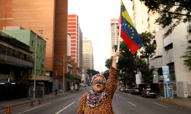 A supporter of Venezuelan President Nicolas Maduro holds a flag of Venezuela on a street near Miraflores Palace in Caracas, Venezuela. &ndash; Reuters