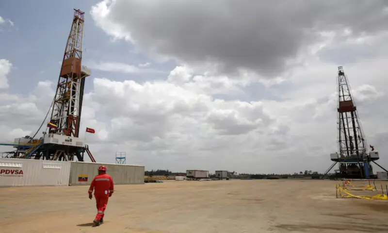 An oilfield worker walks next to drilling rigs at an oil well operated by Venezuela&rsquo;s state oil company PDVSA, in the oil-rich Orinoco belt, near Morichal at the state of Monagas. &ndash; Reuters file