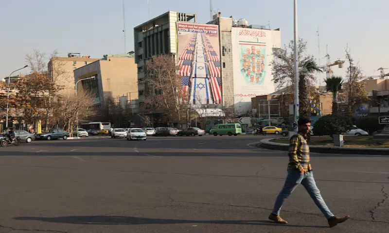 A man walks near an anti-US and anti-Israeli billboard displayed on a building in Tehran, Iran. &ndash; Reuters