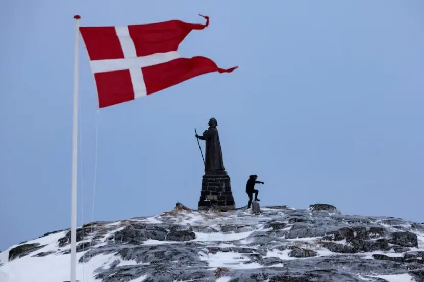 A man walks as Danish flag flutters next to Hans Egede Statue in Nuuk, Greenland, on March 9, 2025. Reuters
