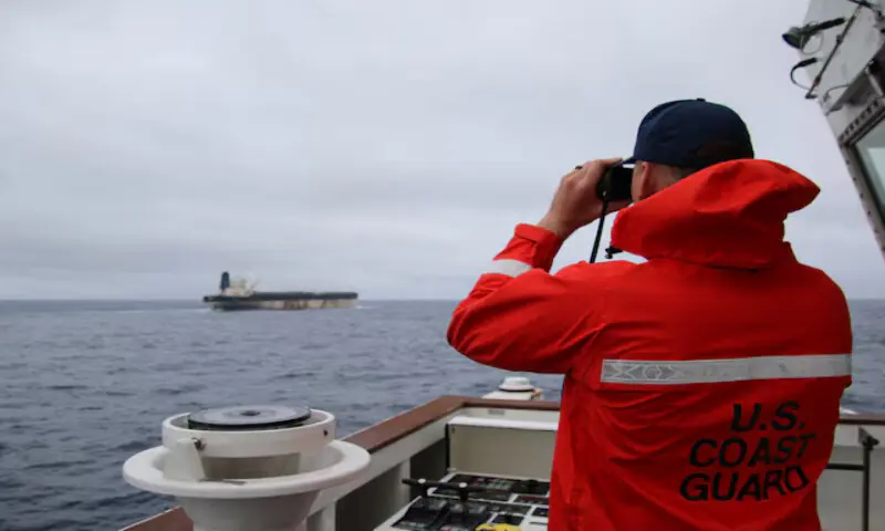 A US Coast Guard official looks through binoculars at the ship Marinera (Ex-Bella 1) in this handout image. &ndash; Reuters