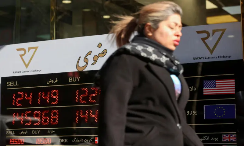 A person walks past a sign at a currency exchange, as the value of the Iranian Rial drops, in Tehran, Iran. &ndash; Reuters