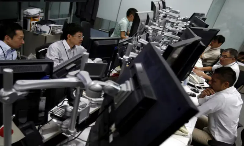 Employees of a foreign exchange trading company work in front of monitors in Tokyo. &ndash; Reuters