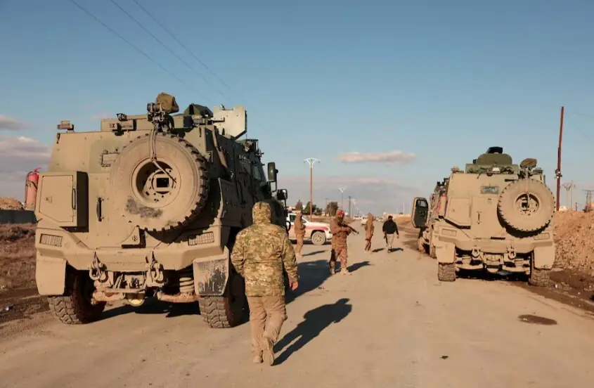 Military members gather near the Raqqa prison, where the Syrian army is besieging SDF members after the army took control of the city of Raqqa, Syria, on January 19, 2026. Reuters