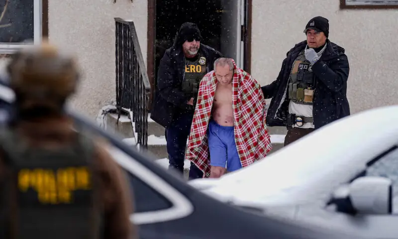 A man is detained after ICE agents and other law enforcement officers conducted an immigration raid at his home in St. Paul, Minnesota. &ndash; Reuters