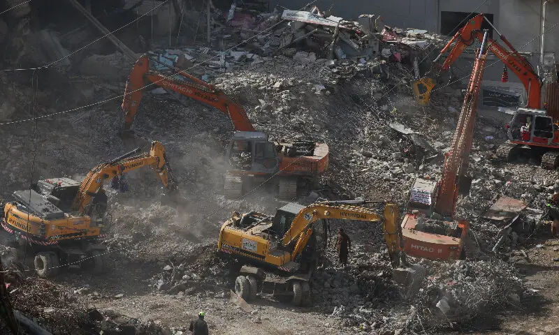 Municipal workers use heavy machinery to clear the rubble following the massive fire at Gul Plaza Shopping Mall in Karachi. &ndash; Reuters