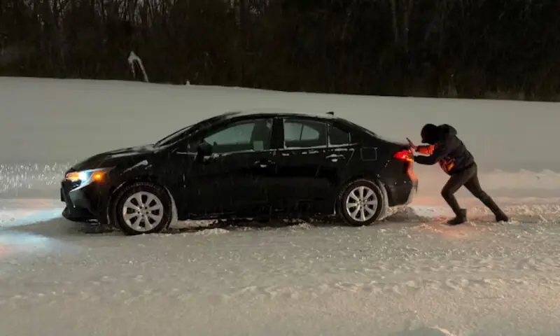 A man pushes his car amid snowfall as winter storm Fern leaves drivers stranded in Tulsa, Oklahoma. &ndash; Reuters