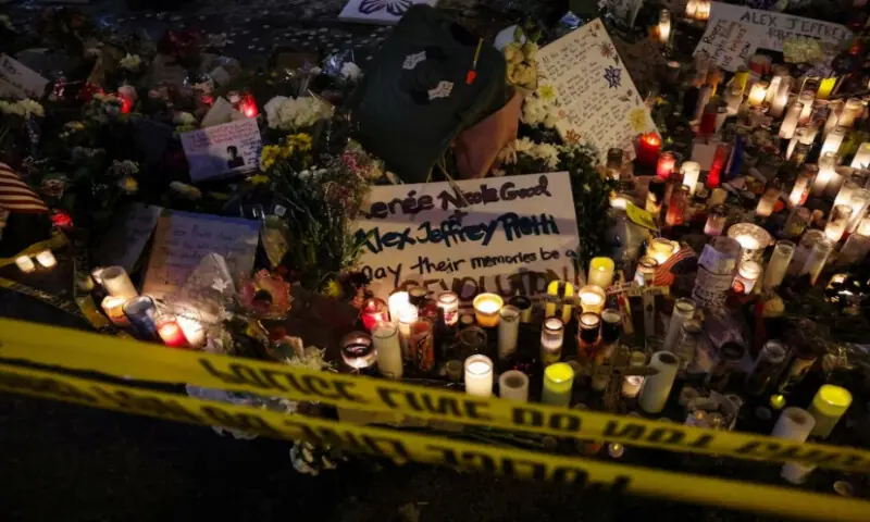 Police tape hangs in front of a makeshift memorial at the site where a man identified as Alex Pretti was fatally shot by federal immigration agents trying to detain him, in Minneapolis, Minnesota, U.S., on January 26, 2026. Reuters