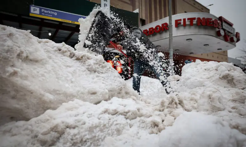 A worker clears snow from the entrance to a parking lot, as a major winter storm spreads across a large swath of the United States, in New York City, US. &ndash; Reuters