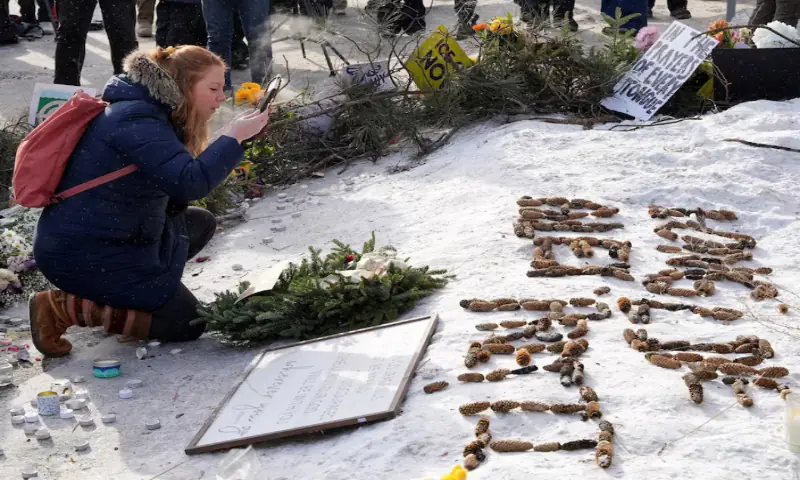 A woman clears snow from a picture of Alex Pretti at a makeshift memorial at the site where a man identified as Pretti was fatally shot by federal immigration agents trying to detain him, in Minneapolis, Minnesota, US. &ndash; Reuters