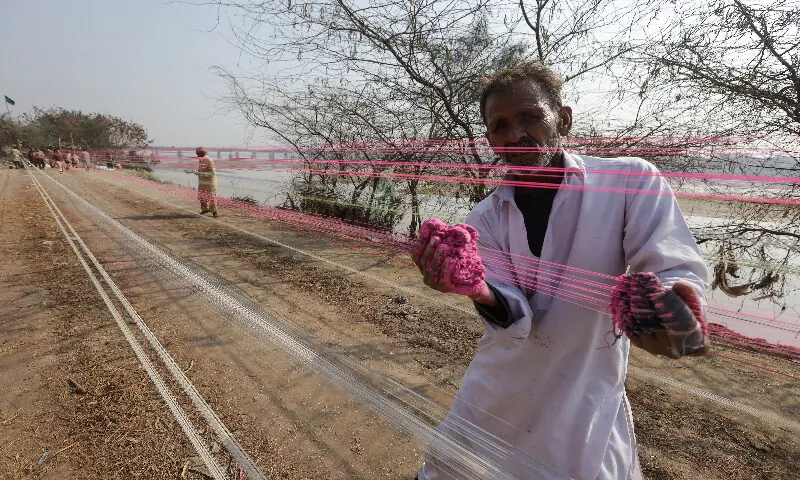 A worker applies a paste of powdered glass to prepare kite strings for the Basant festival in Lahore. &ndash; Reuters