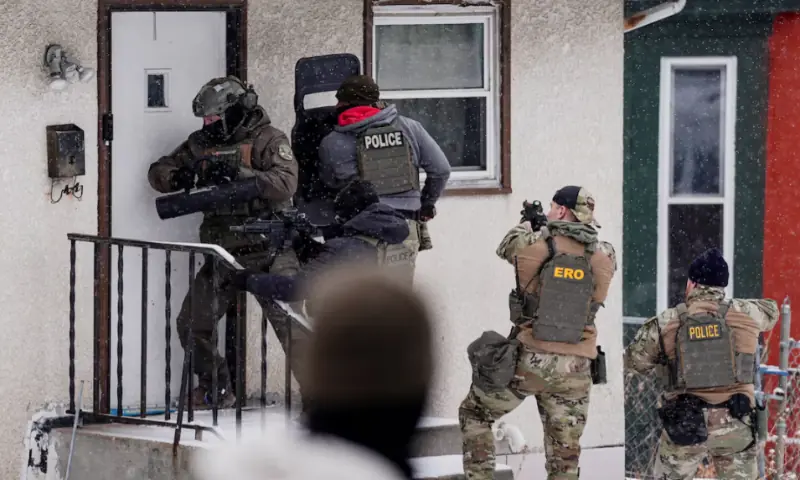 A law enforcement officer uses a battering ram to force entry into a home during an immigration raid in St. Paul, Minnesota, U.S., days after an ICE agent fatally shot Renee Nicole Good on January 18, 2026. Reuters file