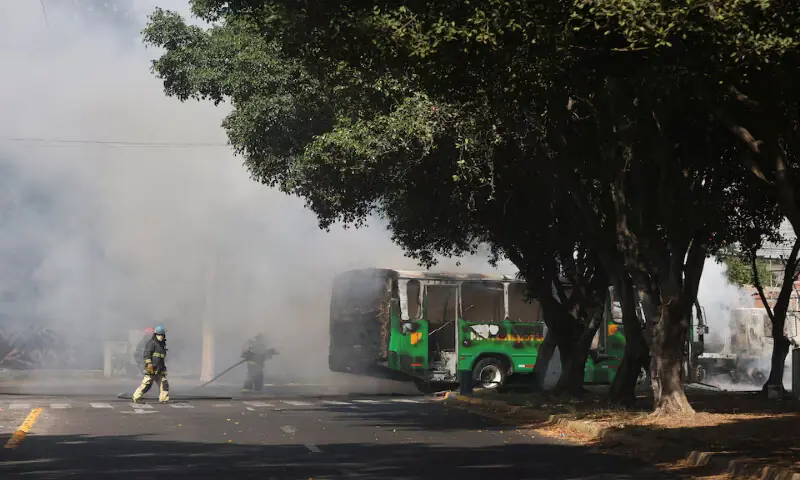 Firefighters work to extinguish flames from a vehicle used by organised crime members as roadblock following a series of detentions by federal forces in Guadalajara, Mexico. &ndash; Reuters