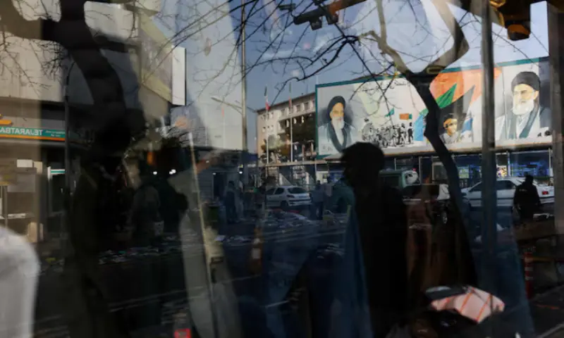 A sign with a depiction of Iran&rsquo;s Supreme Leader, Ayatollah Ali Khamenei, is reflected in a shop window in Tehran, Iran. &ndash; Reuters
