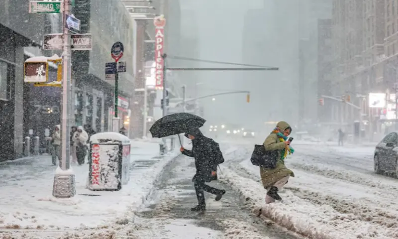 Pedestrians walk on a street as snow falls during a winter storm in New York City, U.S., on February 23, 2026. Reuters