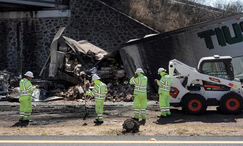 Workers stand next to the wreckage of a trailer used to block a highway after a series of blockades and attacks by organised crime following a military operation in which cartel boss Nemesio Oseguera, &ldquo;El Mencho,&rdquo; was killed, in Ecuandureo, Mexico. &ndash; Reuters