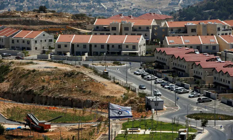 The Israeli national flag flutters as apartments are seen in the background in the Israeli settlement of Efrat in the Israeli-occupied West Bank. &ndash; Reuters