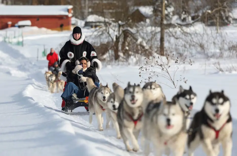 Fatma Albalushi, a tourist from Oman, rides in a sledge pulled by huskies at Husky Land Park in the Moscow region, Russia. &ndash; Reuters
