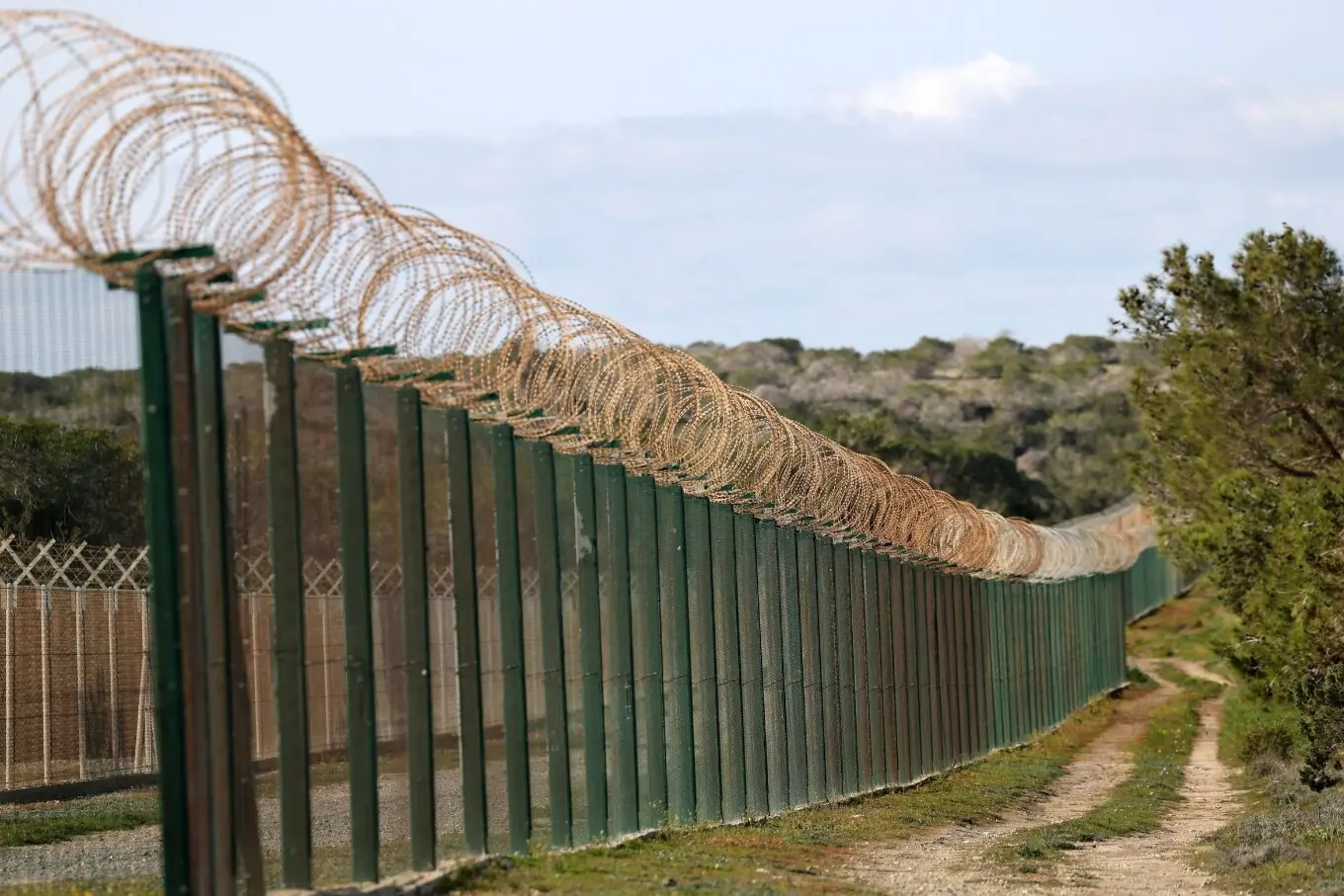 اکروتیری، قبرص میں برطانوی حکومتی اڈے کے داخلی دروازے پر باڑ لگی ہے۔ اکروتیری، قبرص میں برطانوی حکومتی اڈے کے داخلی دروازے پر باڑ لگی ہے۔