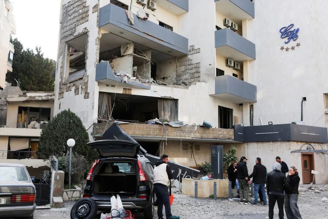 ہزمیہ، لبنان میں لوگ اسرائیلی حملے کے بعد ایک نقصان شدہ عمارت کے پاس کھڑے ہیں۔ ہزمیہ، لبنان میں لوگ اسرائیلی حملے کے بعد ایک نقصان شدہ عمارت کے پاس کھڑے ہیں۔