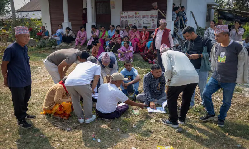 Polling agents from a political party distribute voter slips to people outside a polling station at a village, in Jhapa district, Nepal. &ndash; Reuters