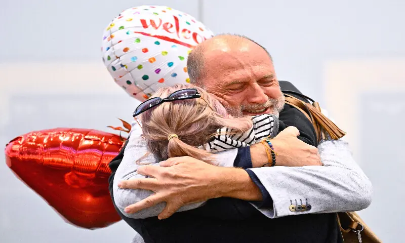 Air travellers, who were stranded in Dubai, are greeted upon arrival at the airport in Schwechat near Vienna, on March 5, 2026. AFP