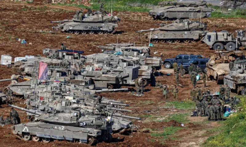 Israeli soldiers gather near vehicles on the Israeli side of the Israel-Lebanon border, following an escalation between Hezbollah and Israel amid the U.S.-Israeli conflict with Iran, in northern Israel, on March 9, 2026. Reuters